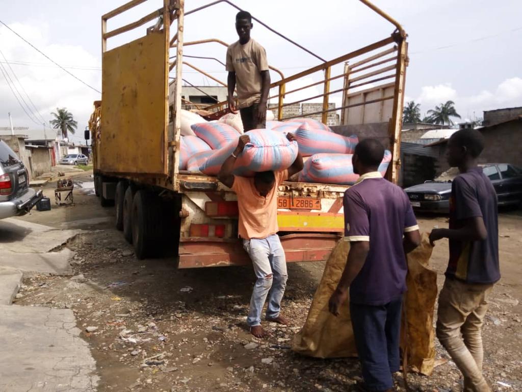 Des personnes transportant des sacs de soja. Image d'illustration