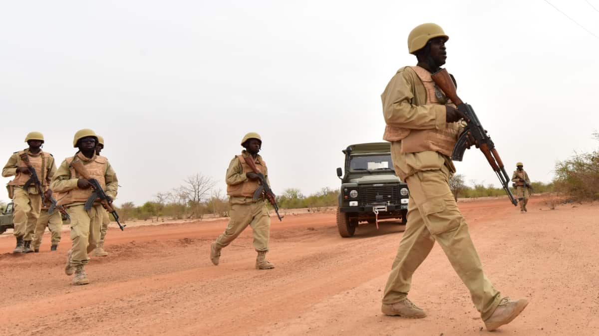 Des militaires marchent devant un camp militaire à Ouagadougou