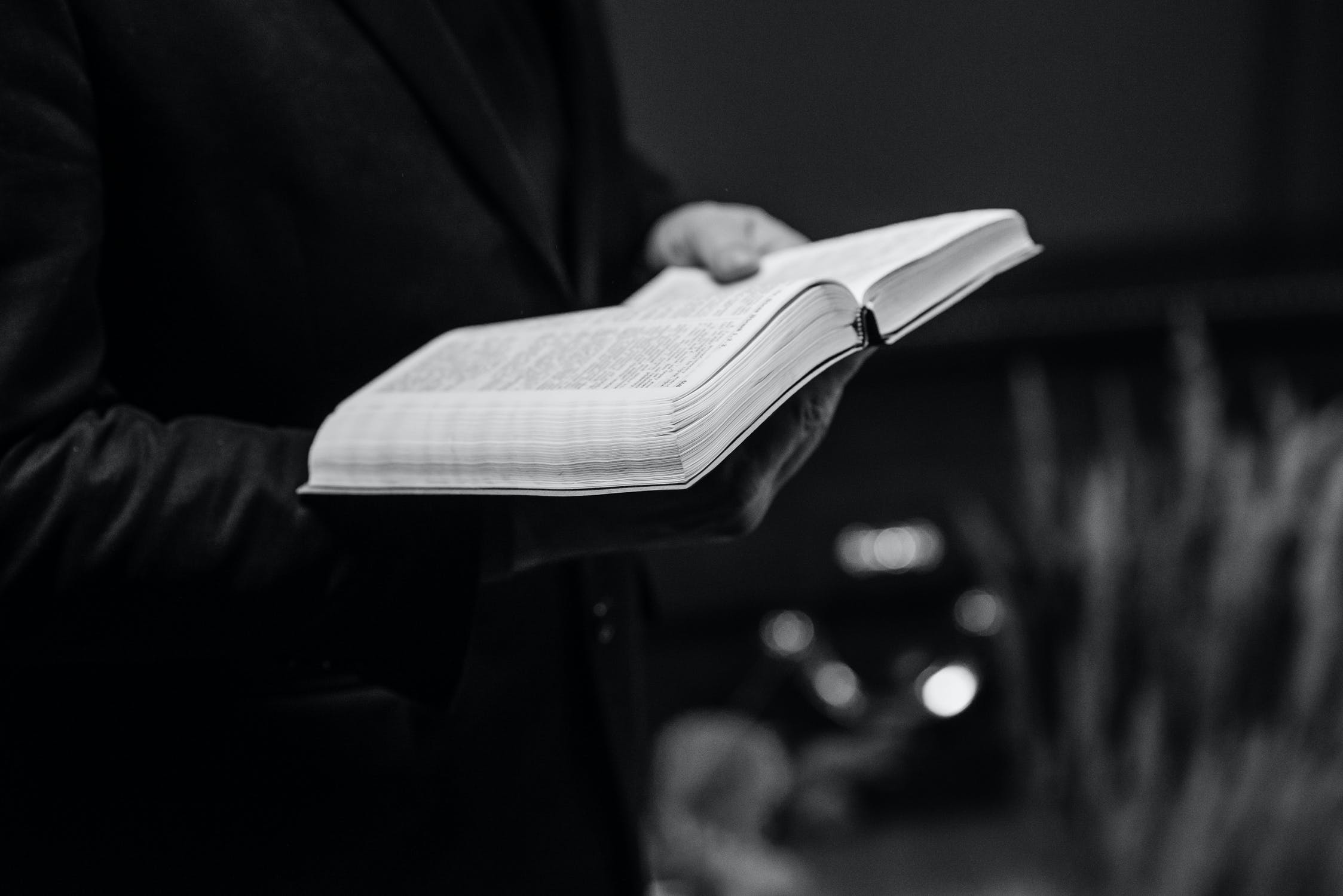 Un pasteur tenant une bible en main. Image d'illustration