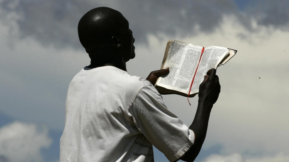 Un pasteur tenant une bible en main. Image d'illustration